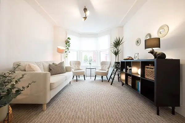 Wall to wall rugs covering a complete living room floor with consistent texture and neatly finished room edges